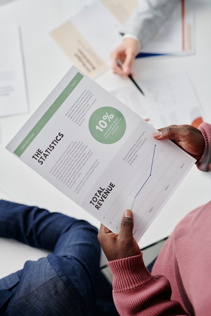 Adults reviewing statistical business reports in a professional office environment.